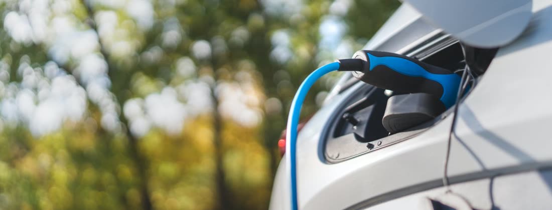 Carga de coche eléctrico en estación de recarga sostenible