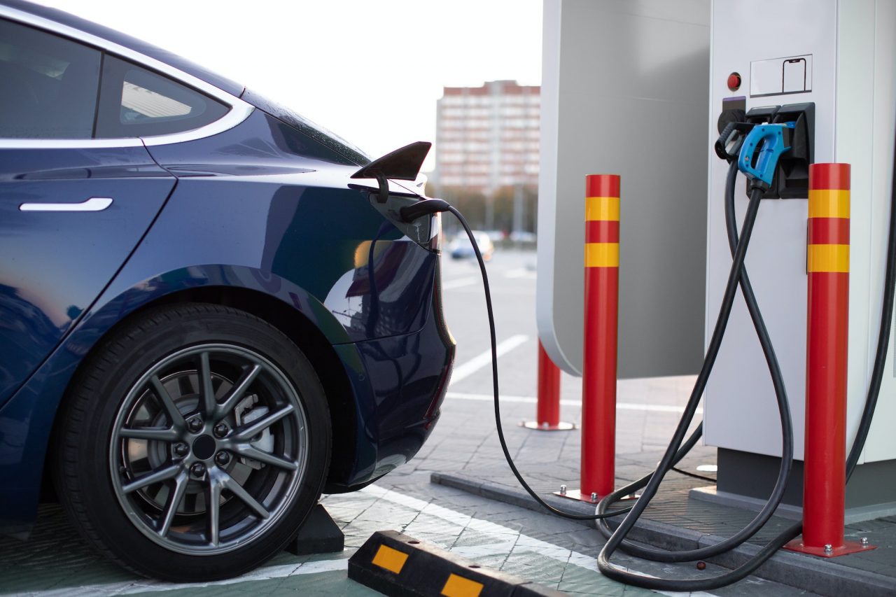 Vehículo eléctrico cargando en una estación de carga en la calle