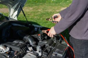 Técnico conectando pinzas de diagnóstico a la batería del vehículo